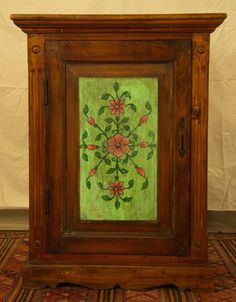 an old wooden clock with flowers painted on it