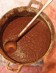 an old rusty pot with a spoon in it