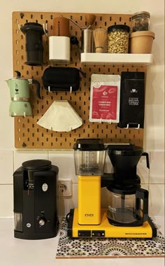 a coffee maker sitting on top of a counter next to a wall mounted spice rack