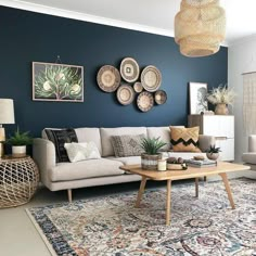 a living room with blue walls and rugs on the floor in front of it