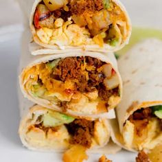 three burritos stacked on top of each other with meat, cheese and vegetables