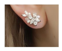 a close up of a person wearing a pair of ear piercings with flowers on them