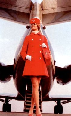 a woman standing in front of an airplane