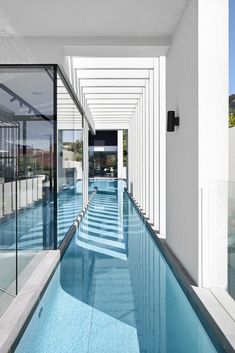 an indoor swimming pool with glass doors leading to it