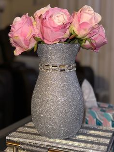 some pink roses are in a silver vase