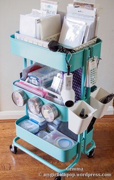 a blue cart filled with lots of items on top of a hard wood floor