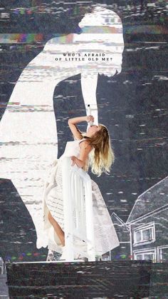 a woman standing on top of a white chair in front of a wall with an image of a person