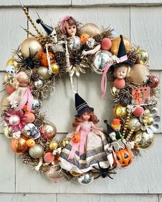 a wreath with an image of a witch and pumpkins hanging on the front door