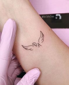 a woman's arm with a small bird tattoo on the left side of her leg