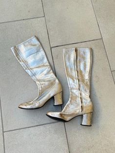 1960s Silver Metallic Leather Gogo Boots by Millie's. Women's size 5.5 B. Metal side zipper on inner side of boots. They are just below knee high length with shaft measuring 14" from top of boot to the top of the heel and 16.5" total length from top to bottom of boot. 3" wide measurement taken from bottom of sole. Soles look to be in excellent condition. Chunky 2.5" heel. Round square toe shape. There are obvious signs of previous wear and age: surface scuffs and wear and a few heel nicks. Perfe Vintage Party Boots, Vintage Knee-high Boots For Party, Retro Leather Party Boots, Retro Fall Heeled Boots, Vintage Leather Heeled Boots For Party, Vintage Leather Party Boots, Vintage Leather Boots For Party, Gogo Boots, San Rafael