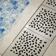 a blue and white tiled floor next to a swimming pool with holes in the water