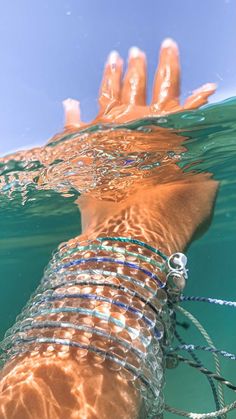 a person swimming in the water with their hand on top of some kind of wire