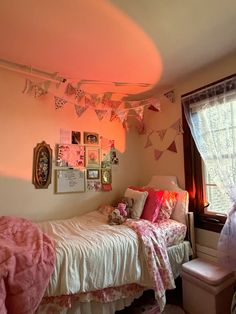 a bed room with a neatly made bed next to a window and pictures on the wall