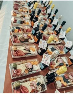 a table topped with lots of different types of cheese and meats next to bottles of wine