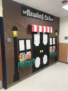 a classroom door decorated like a train with flowers on the window and lights above it