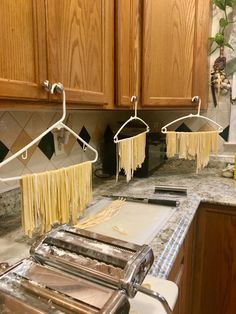 two pasta cutters are hanging on the kitchen counter