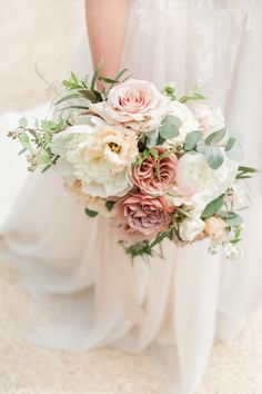 a bridal holding a bouquet of pink and white flowers