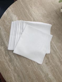 four white napkins sitting on top of a marble table