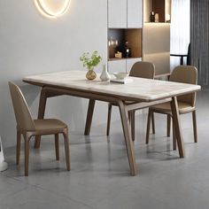 a dining room table and chairs in front of a wall with a circular light above it