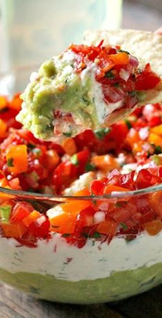 a tortilla salad with tomatoes and guacamole in a glass bowl