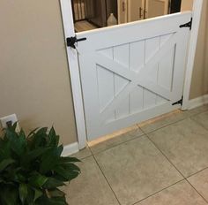 a white barn door with black hardware on the bottom and side panels is opened to reveal a living room