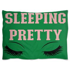 a green pillow with the words sleeping pretty on it and an eye drawn in pink