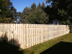 a wooden fence in front of some trees