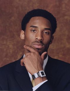 a man in a suit and tie with his hand on his chin looking at the camera