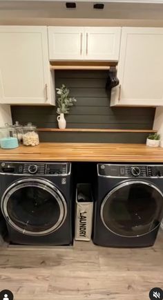 a washer and dryer sitting next to each other in a room with white cabinets