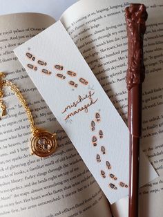 an open book with some writing on it next to a harry potter wand and charm