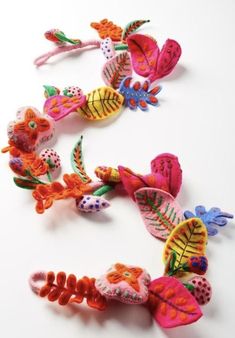 several colorful hair clips with flowers and leaves on them, all in the same pattern