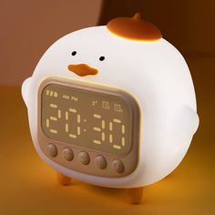 an alarm clock with a chicken face on it's face is shown in front of a brown background