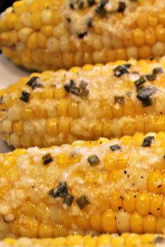 three corn on the cob with herbs and seasoning