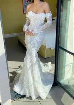 a woman in a white wedding dress posing for the camera