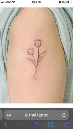 a small flower tattoo on the back of a woman's arm, which has been drawn