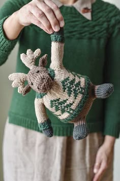 a knitted giraffe ornament being held by a woman