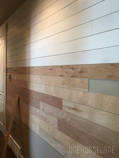 wood paneling on the side of a wall in a room with white walls and wooden floors