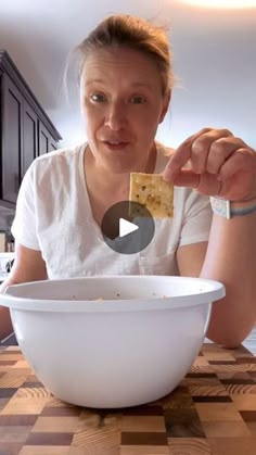 a woman is eating crackers out of a bowl