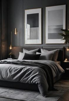 a bedroom with dark walls and grey bedding, two framed pictures on the wall