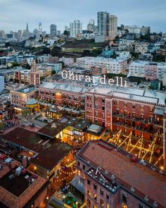 an aerial view of the city with lights and buildings in the foreground, at night