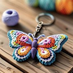 a crocheted butterfly keychain sitting on top of a wooden table