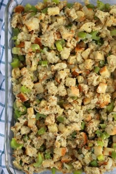 a casserole dish with stuffing and vegetables in it on a blue checkered cloth