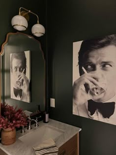 a bathroom with two pictures on the wall and a sink in front of it,