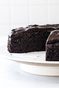 a chocolate cake on a plate with one slice cut out and ready to be eaten