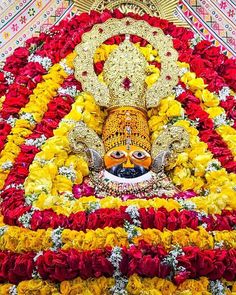 a statue made out of flowers in the shape of a person's head and eyes