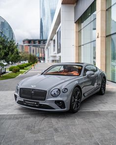 a grey car parked in front of a building