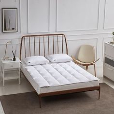 a bed with white sheets and pillows in a room