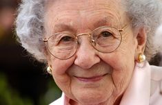 an old woman with glasses smiling for the camera