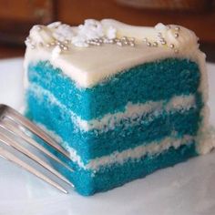 a piece of blue and white cake on a plate with a fork