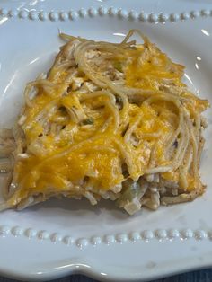 a white plate topped with pasta covered in cheese